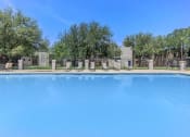 Thumbnail 4 of 54 - a large pool with trees and chairs around it