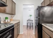 Thumbnail 30 of 54 - a kitchen with stainless steel appliances and a black refrigerator