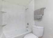 Thumbnail 44 of 54 - a white bathroom with a white toilet and a bath tub