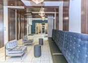 Thumbnail 11 of 28 - a lobby with a blue couch and chairs