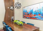 Thumbnail 13 of 28 - a conference room with a wooden table and chairs and a large painting on the wall
