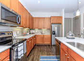 Thumbnail 4 of 28 - a kitchen with wooden cabinets and stainless steel appliances