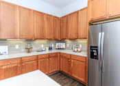 Thumbnail 22 of 28 - a kitchen with wooden cabinets and a stainless steel refrigerator