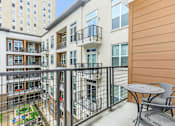 Thumbnail 8 of 28 - a balcony with a table and chairs and a building in the background