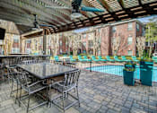 Thumbnail 6 of 40 - a patio with a table and chairs next to a swimming pool