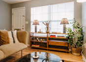 Thumbnail 1 of 35 - a living room with a couch and a coffee table and a window