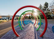 Thumbnail 16 of 35 - a row of rainbow hula hoops in a park