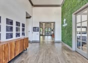 Thumbnail 7 of 14 - a hallway with large glass doors and a green wall on the side of a building