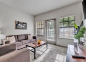 Thumbnail 1 of 14 - a living room with a couch and a coffee table