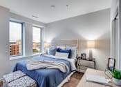 Thumbnail 3 of 39 - A bedroom with a large bed and a window overlooking a cityscape.
