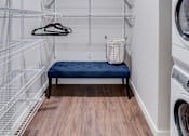 Thumbnail 4 of 39 - A laundry room with a bench and a washing machine.