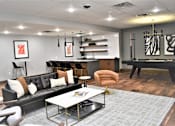 Thumbnail 17 of 39 - A modern living room with a black couch and a coffee table.