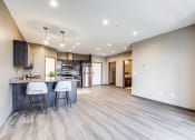 Thumbnail 3 of 26 - an open kitchen and living room with a kitchen island and bar stools