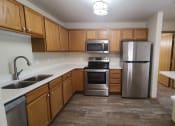 Thumbnail 10 of 28 - a kitchen with stainless steel appliances and wooden cabinets
