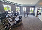 Thumbnail 9 of 27 - a gym with cardio equipment and windows in a building
