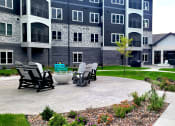 Thumbnail 19 of 27 - an outdoor patio with chairs and a table in front of an apartment building