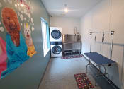 Thumbnail 21 of 27 - a laundry room with a washing machine and a blue table