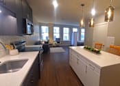 Thumbnail 38 of 39 - A kitchen with white countertops and wooden cabinets.