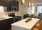 Thumbnail 33 of 39 - A kitchen with a white counter top and a plant on it.