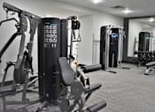 Thumbnail 20 of 39 - A gym with a variety of equipment including a treadmill, a stationary bike and a rowing machine.