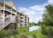 Thumbnail 1 of 28 - a building overlooking a pond with a fountain