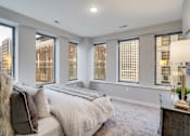 Thumbnail 11 of 39 - A bedroom with a large bed and a view of the city.