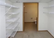 Thumbnail 16 of 28 - a walk in closet with white shelves and a toilet in the distance