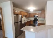 Thumbnail 11 of 28 - an empty kitchen with stainless steel appliances and a marble counter top