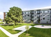 Thumbnail 24 of 26 - an exterior view of Golden Aspen Flats with a pickle ball court, picnic area, grass and trees
