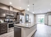 Thumbnail 16 of 25 - A modern kitchen with dark brown cabinets and granite countertops.