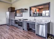 Thumbnail 11 of 25 - A modern kitchen with a wooden floor and stainless steel appliances.