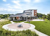 Thumbnail 5 of 25 - A modern building with a circular patio in front.