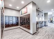Thumbnail 9 of 25 - A modern kitchen with a bar area and a wine rack.