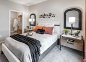 Thumbnail 12 of 37 - a bedroom with a bed and a mirror on the wall