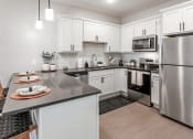 Thumbnail 13 of 37 - an open kitchen with stainless steel appliances and white cabinets