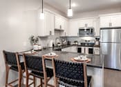 Thumbnail 2 of 37 - spacious kitchen with stainless steel appliances and a island with chairs