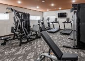 Thumbnail 6 of 37 - a gym with cardio equipment and a tv in the ceiling