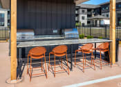 Thumbnail 8 of 37 - a bar with chairs in front of a grill