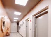 Thumbnail 23 of 37 - a hallway with white walls and white doors and a table with a vase