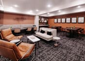 Thumbnail 28 of 37 - a lounge area with couches and chairs and tables