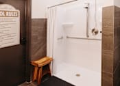 Thumbnail 9 of 37 - a small bathroom with a shower and a wooden stool