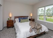 Thumbnail 6 of 37 - A bedroom with a large bed and two lamps.