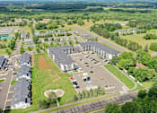 Thumbnail 30 of 37 - A bird's eye view of a large building complex surrounded by trees and a parking lot.