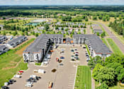Thumbnail 29 of 37 - A parking lot in front of a large building.