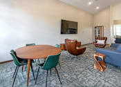 Thumbnail 23 of 37 - A living room with a round wooden table surrounded by chairs.