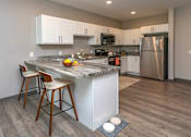 Thumbnail 1 of 37 - A kitchen with a marble island and stainless steel appliances.