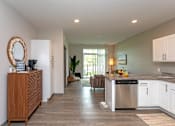 Thumbnail 3 of 37 - A kitchen with white cabinets and a wooden floor.