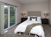 Thumbnail 13 of 37 - A bedroom with a large bed and a sliding glass door.