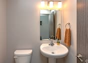 Thumbnail 18 of 37 - A bathroom with a white toilet and a white sink.