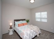 Thumbnail 14 of 37 - A bedroom with a bed, nightstand, and window.